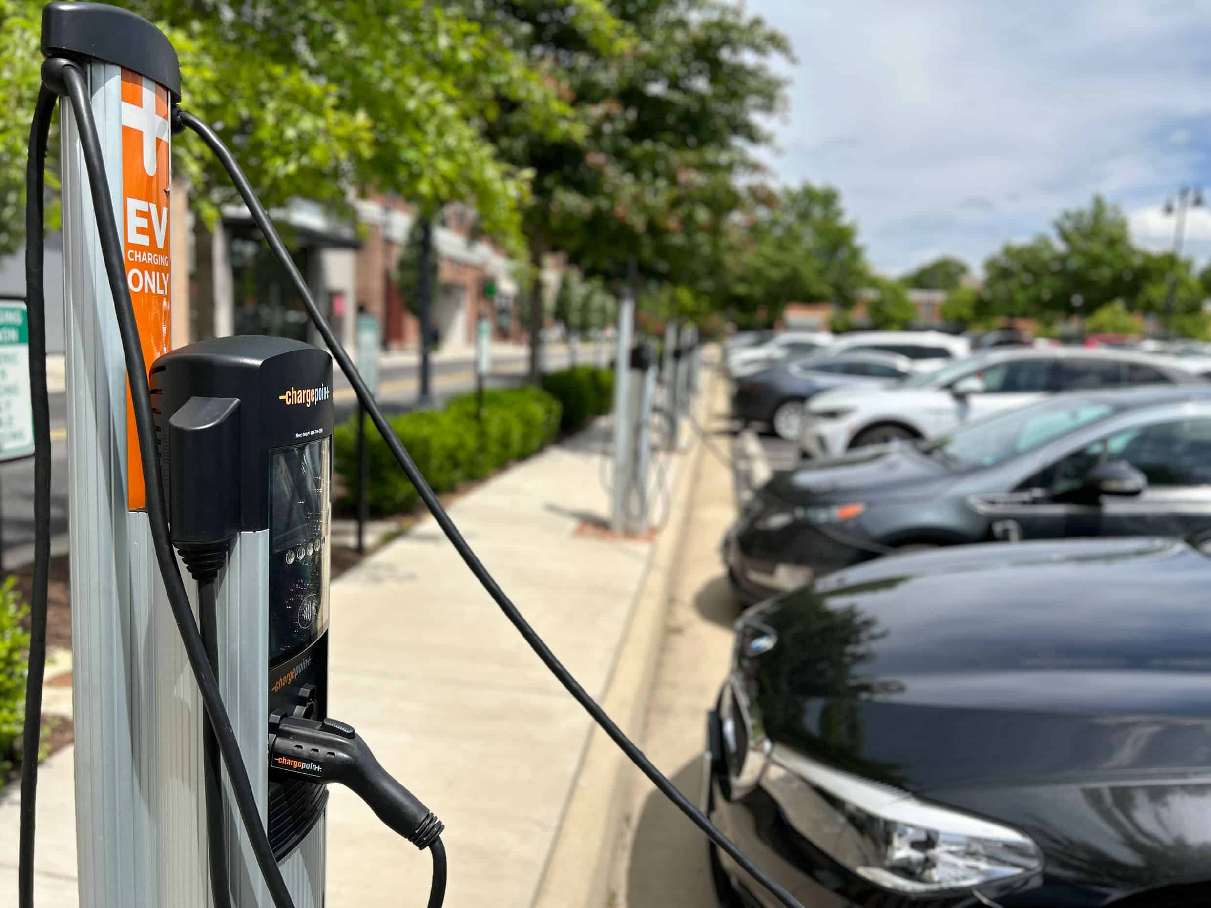 Row of commercial EV chargers in an outdoor parking lot